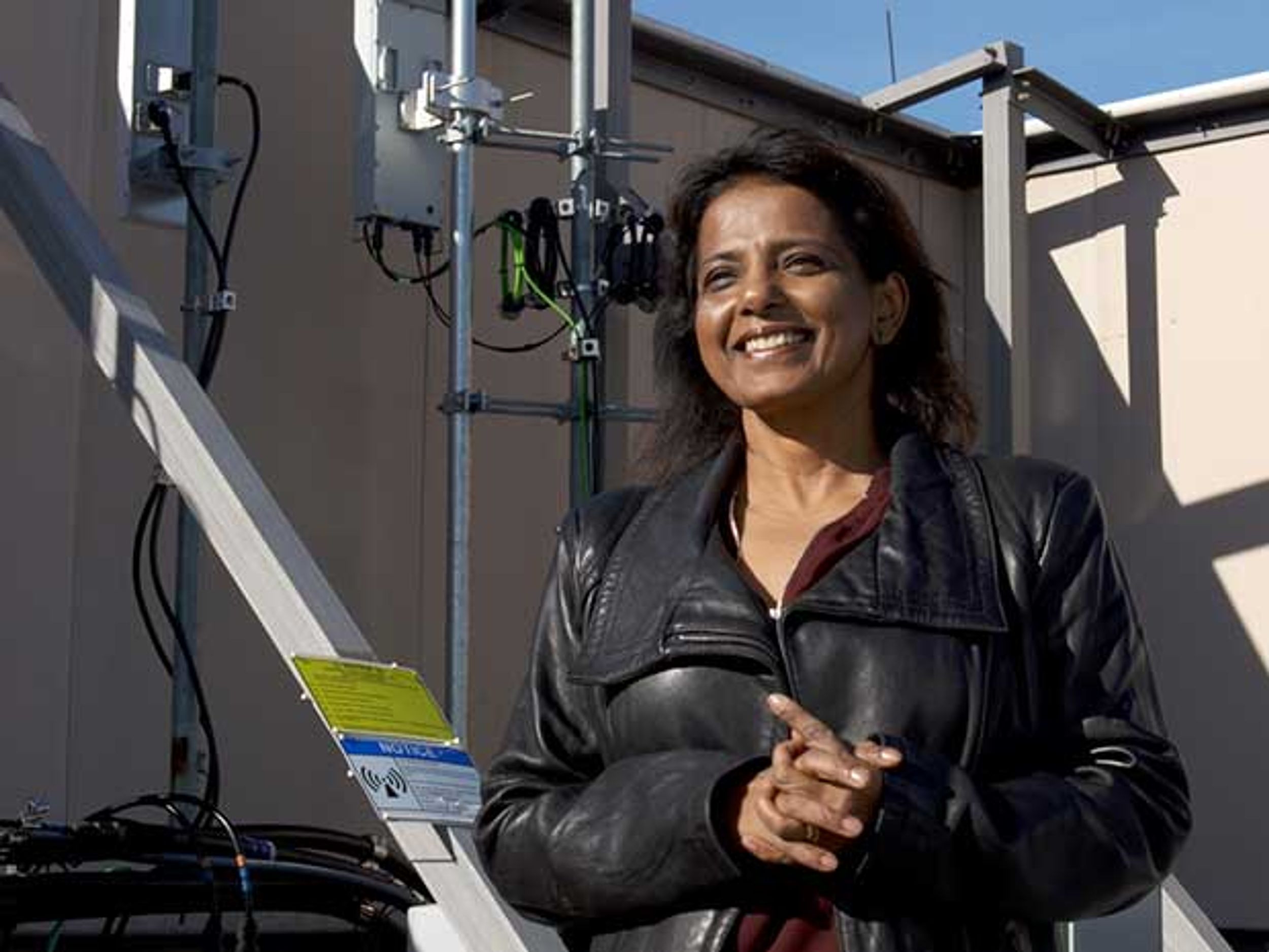 Sanyogita Shamsunder, Verizon's director of network planning, is shown standing outside near equipment used to test new base station technology.