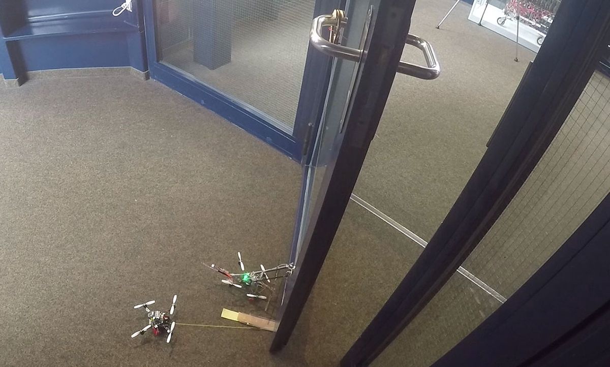 Still image from a video showing the drones collaborating to open a door.