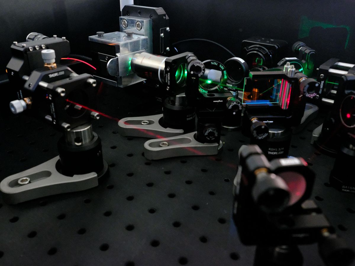 tabletop lasers shining green light through lenses