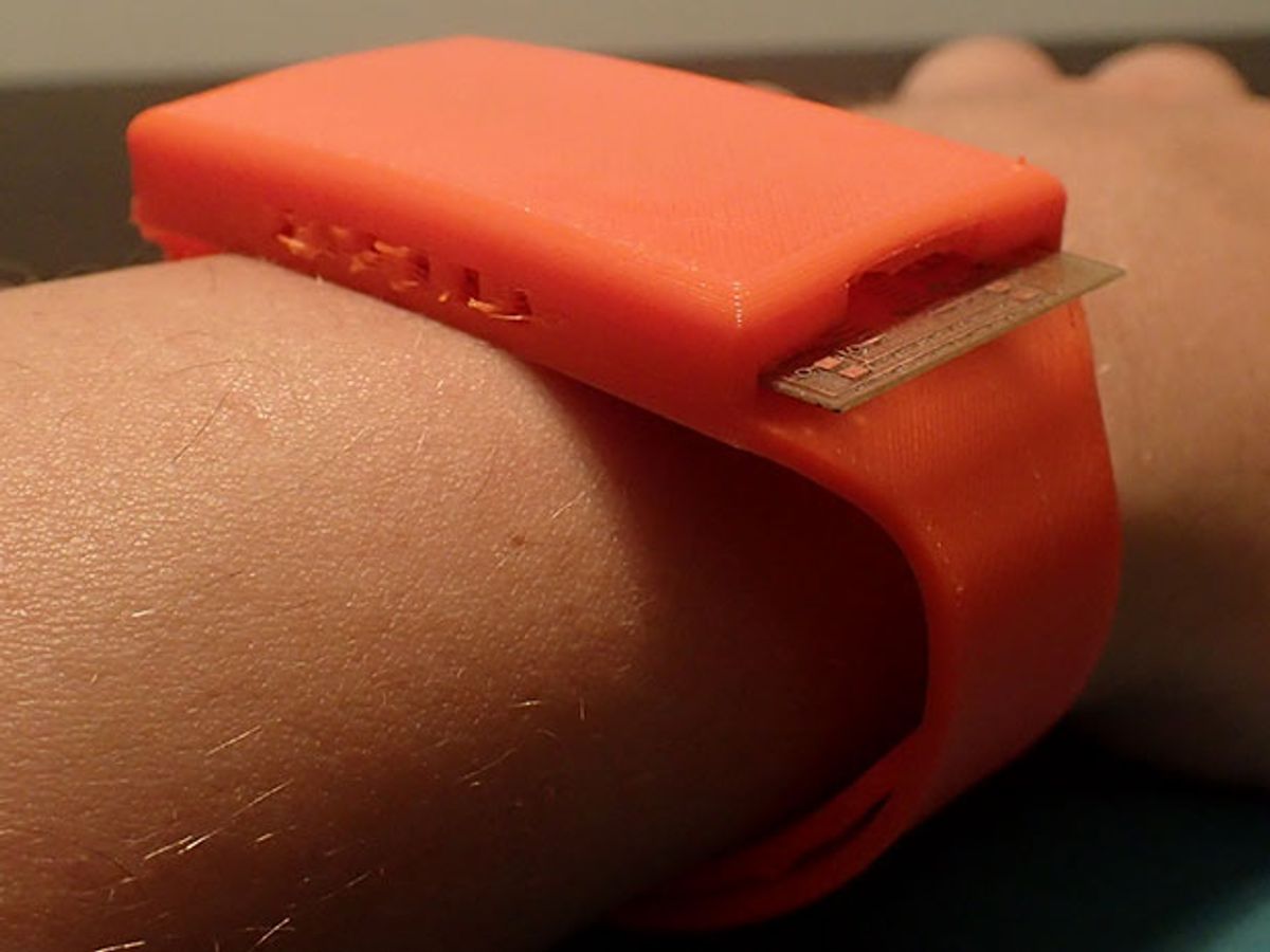 The “paper watch” is an orange wristband with electronic sensors on the underside.