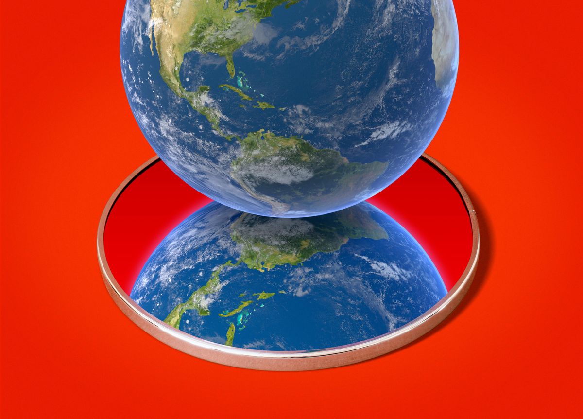 The planet earth sitting on a mirror with another earth in the reflection on a red background.
