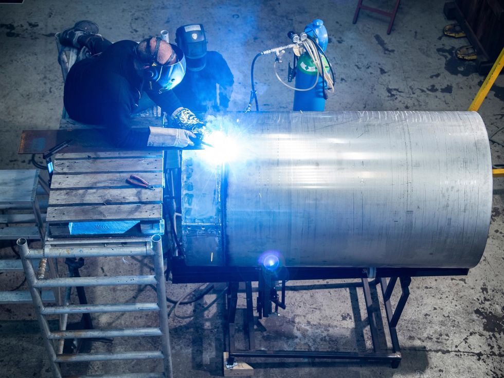 The right photo shows several workers in welding masks welding a seam on a large metal cylinder.