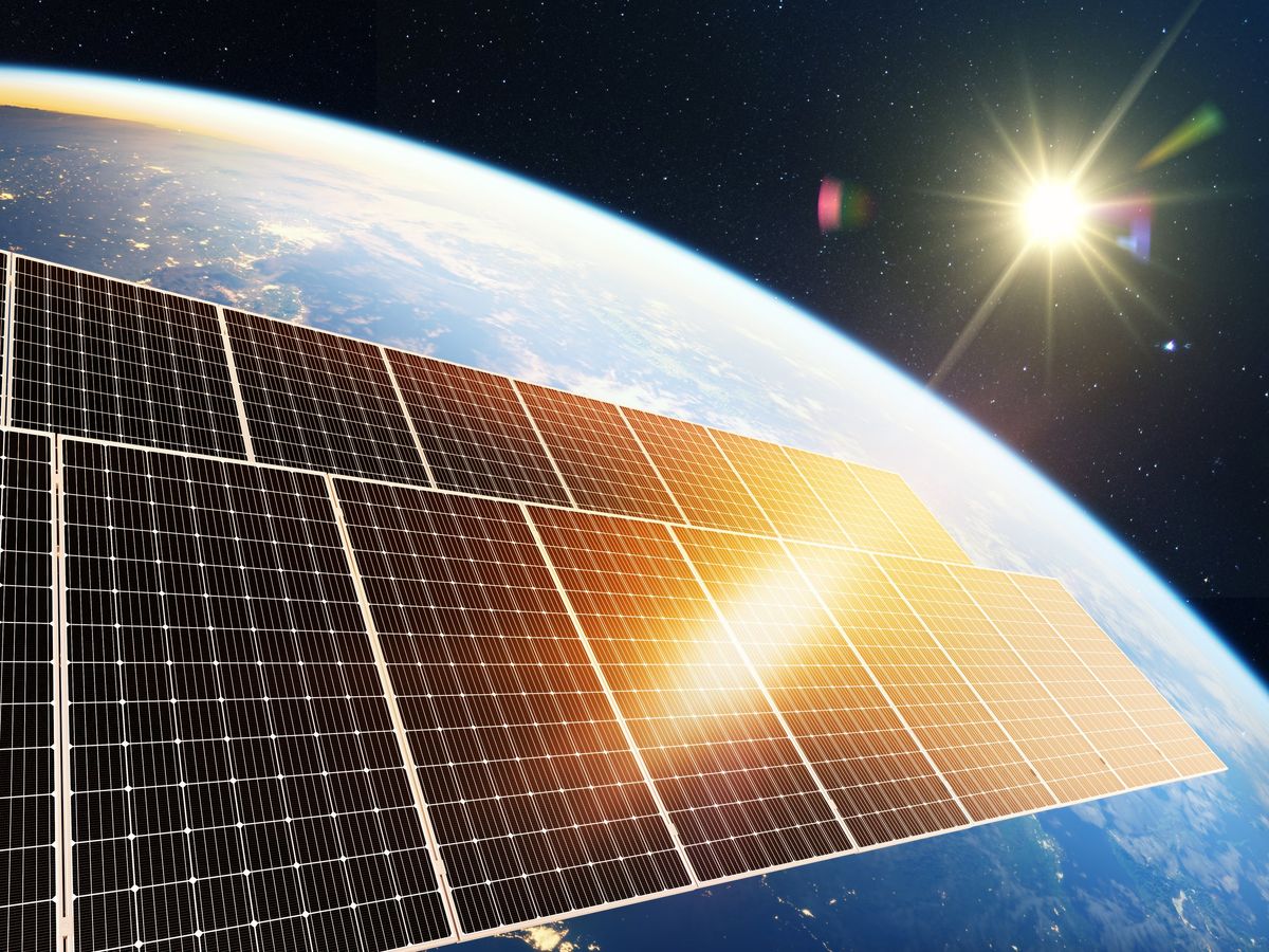 The sun shines on solar panels, in space, over the Earth.