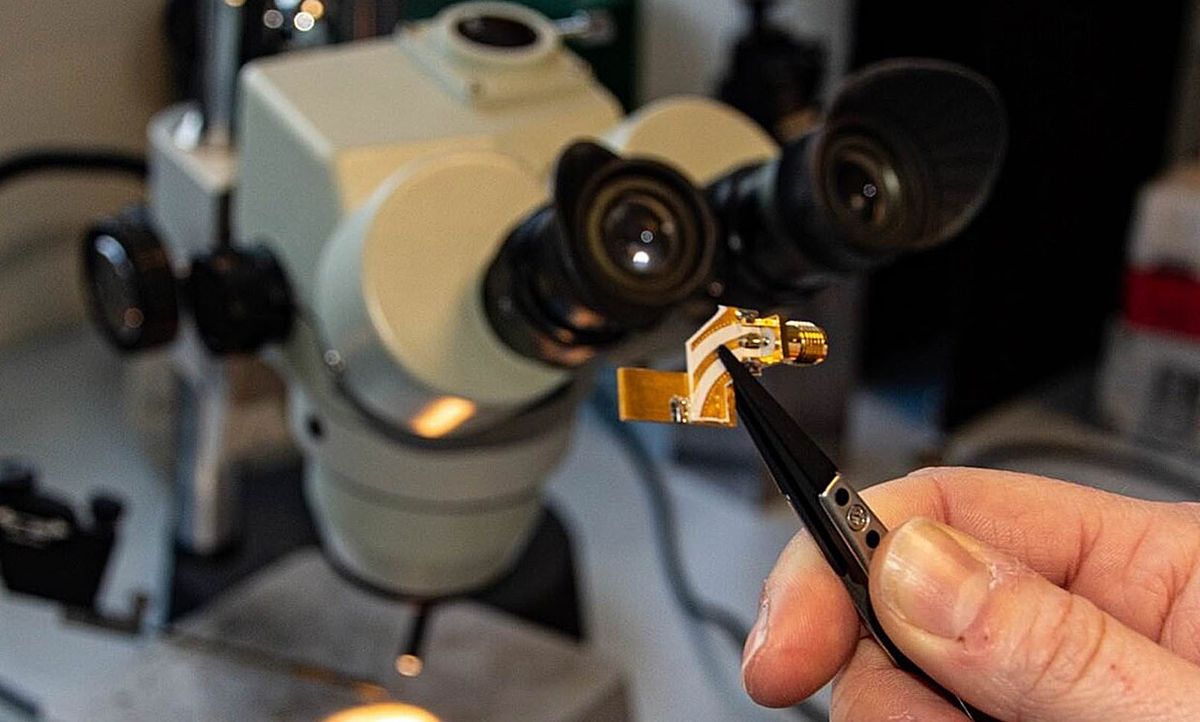 The terahertz quantum cascade laser on its mounting. A pair of tweezers shows how small the device is.