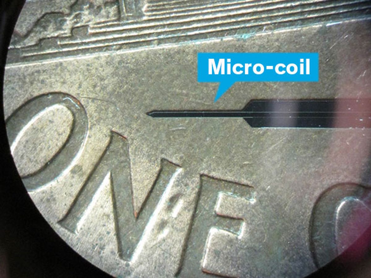 The tiny microcoil that stimulates brain cells via magnetic fields is shown on top of a penny for size comparison.