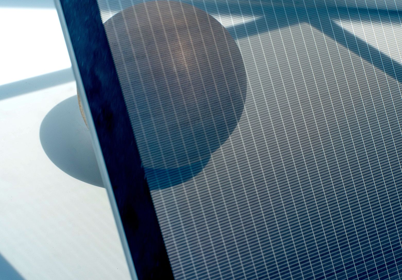 The transparency of a solar panel is highlighted by showing objects behind it, through it.