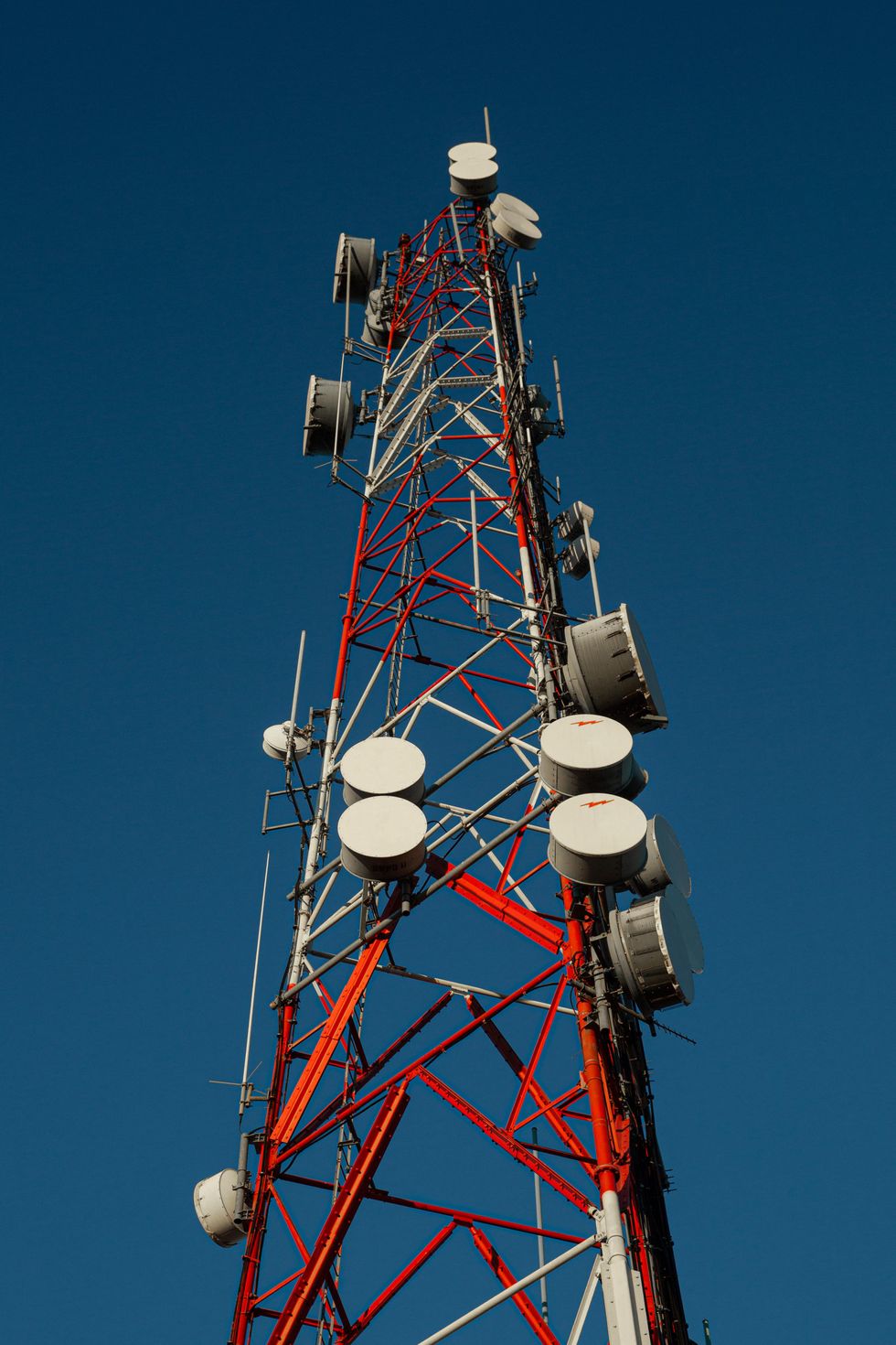 This photo shows a radio tower with many drum-like antennas pointed in various directions.