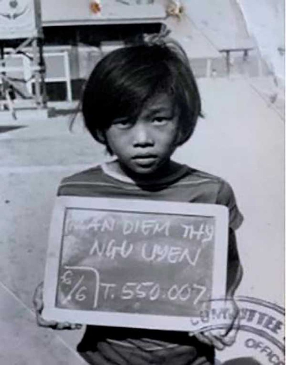 Thy Tran holding a board with her name and refugee number in Lumpini, Thailand in 1979.