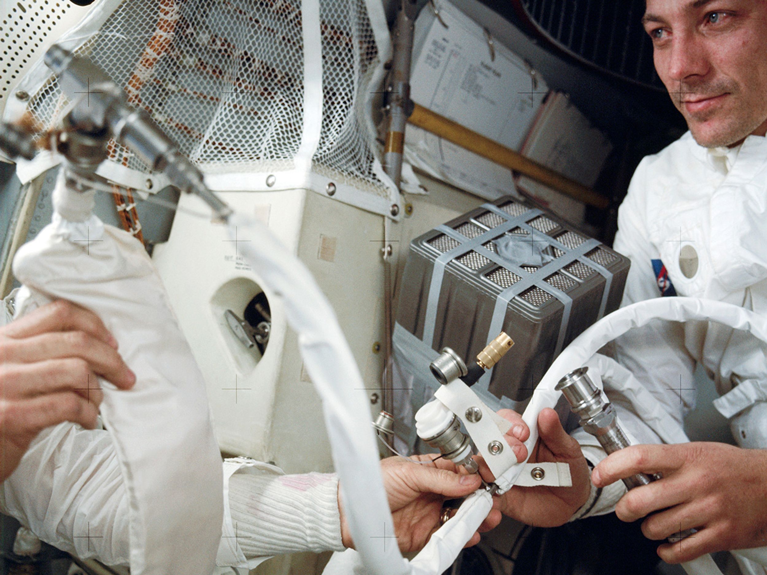 To prevent carbon dioxide poisoning, the crew jury-rigged a filter in the lunar module. Astronaut Jack Swigert is on the left.