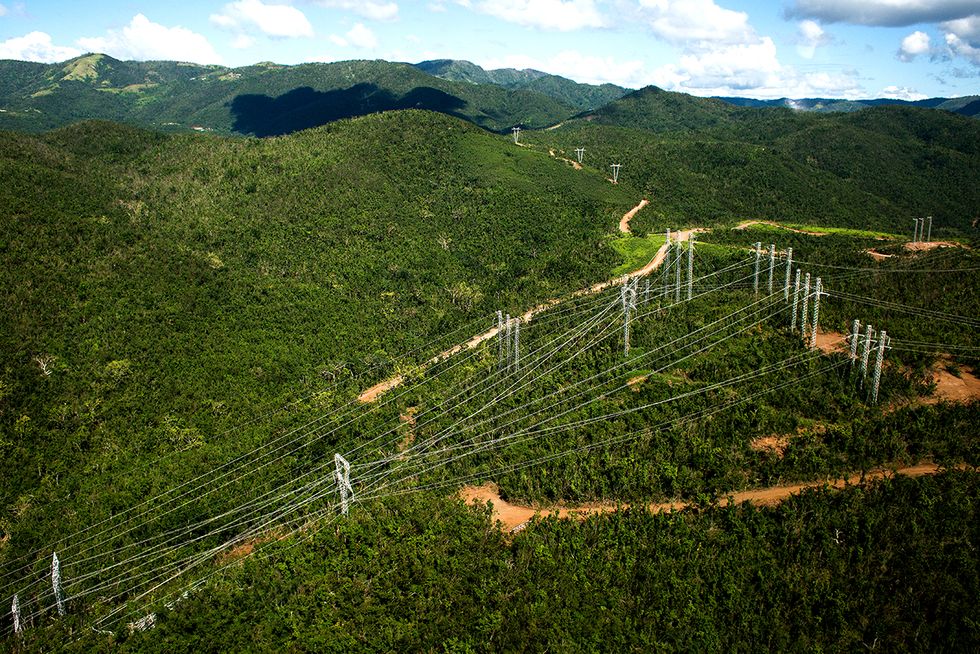Transmission lines cut through mountainous terrain.