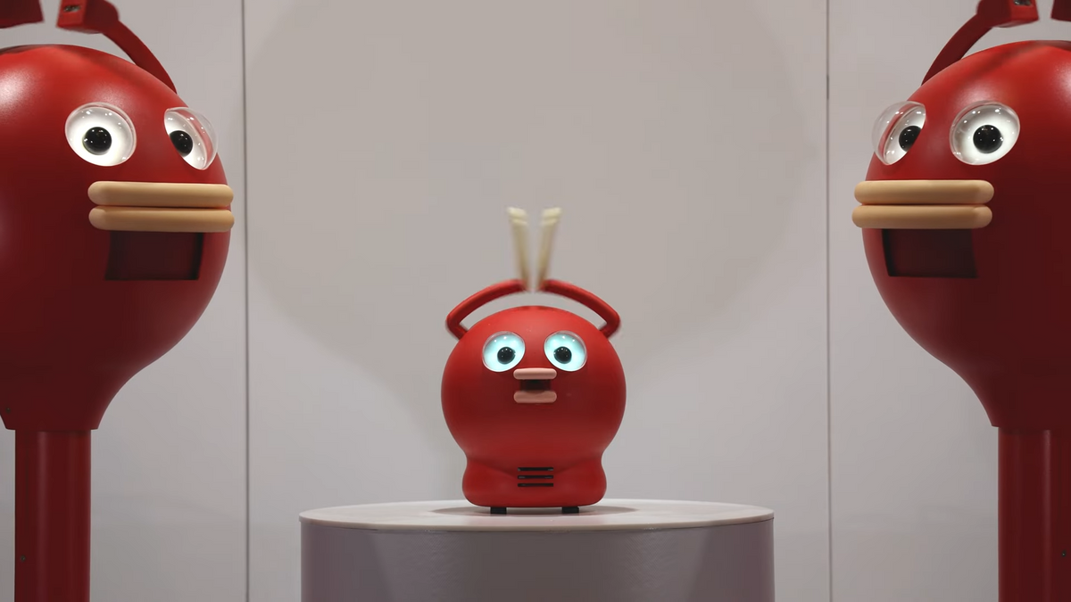 Two cartoonish round red robots with clapping hands above their head next to a smaller, cuter version of the same robot