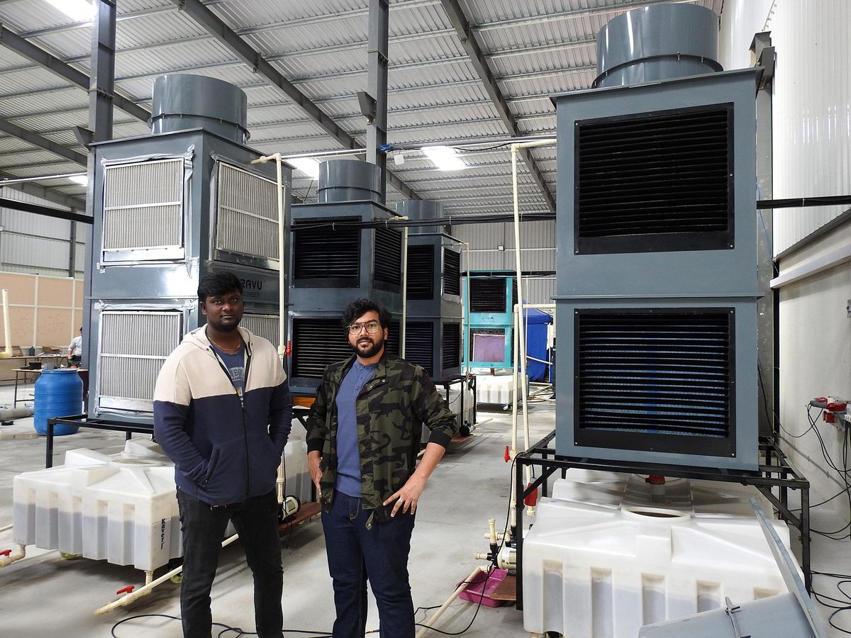 two men standing in front of a metal box system