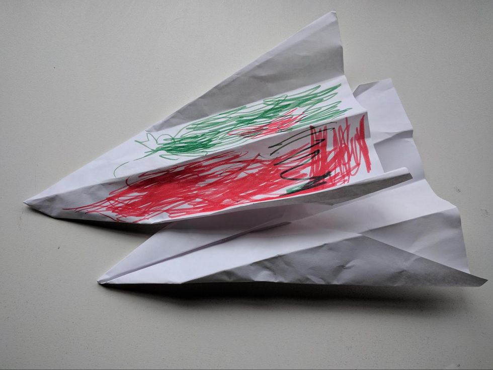 Two paper airplanes that a child gave to DragonBot.