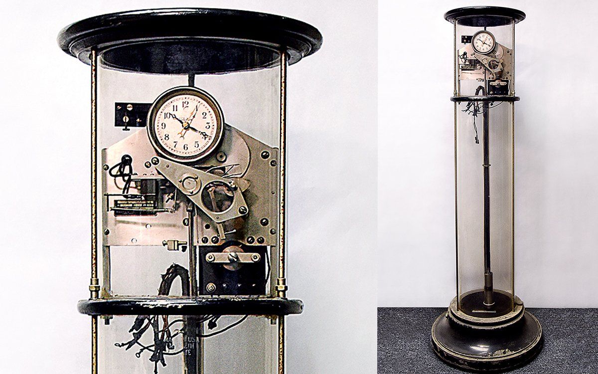 Two photos show a close-up and then a full image of a tall cylindrical apparatus with a clock face. 