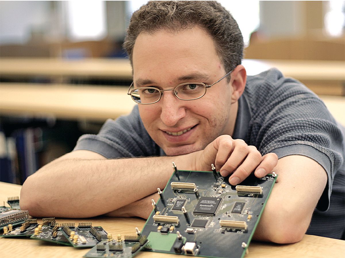 Universal Software Radio Peripheral designer Matt Ettus poses with his invention and some of the daughterboards used to operate in different frequency ranges.