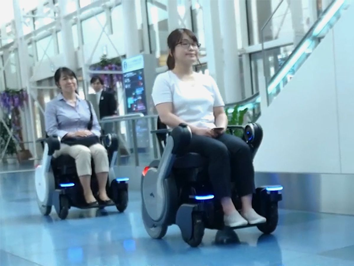 Users sit in two WHILL NEXT wheelchairs in the Haneda Airport in Japan