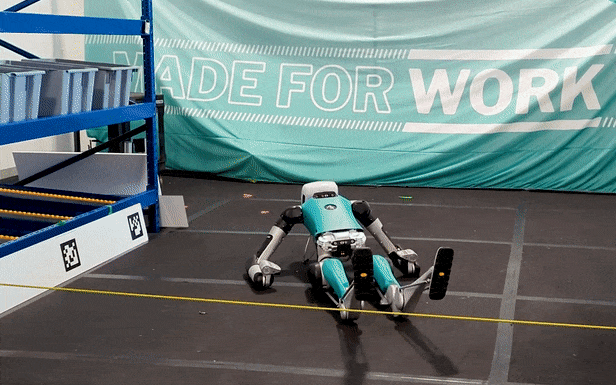 video loop of a teal and gray humanoid robot trying to right itself in front of a banner that says "made for work"