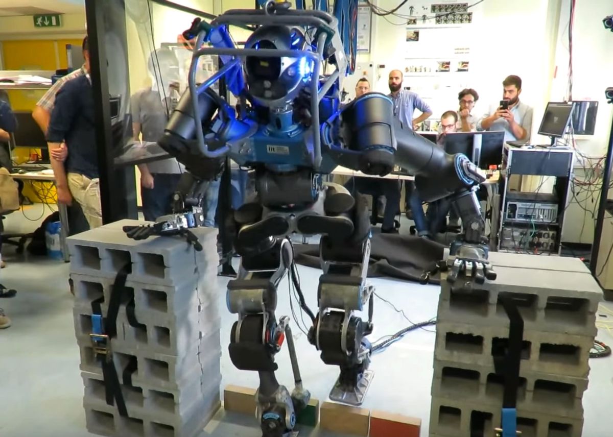 WALK-MAN humanoid robot steps over an obstacle during a demonstration.