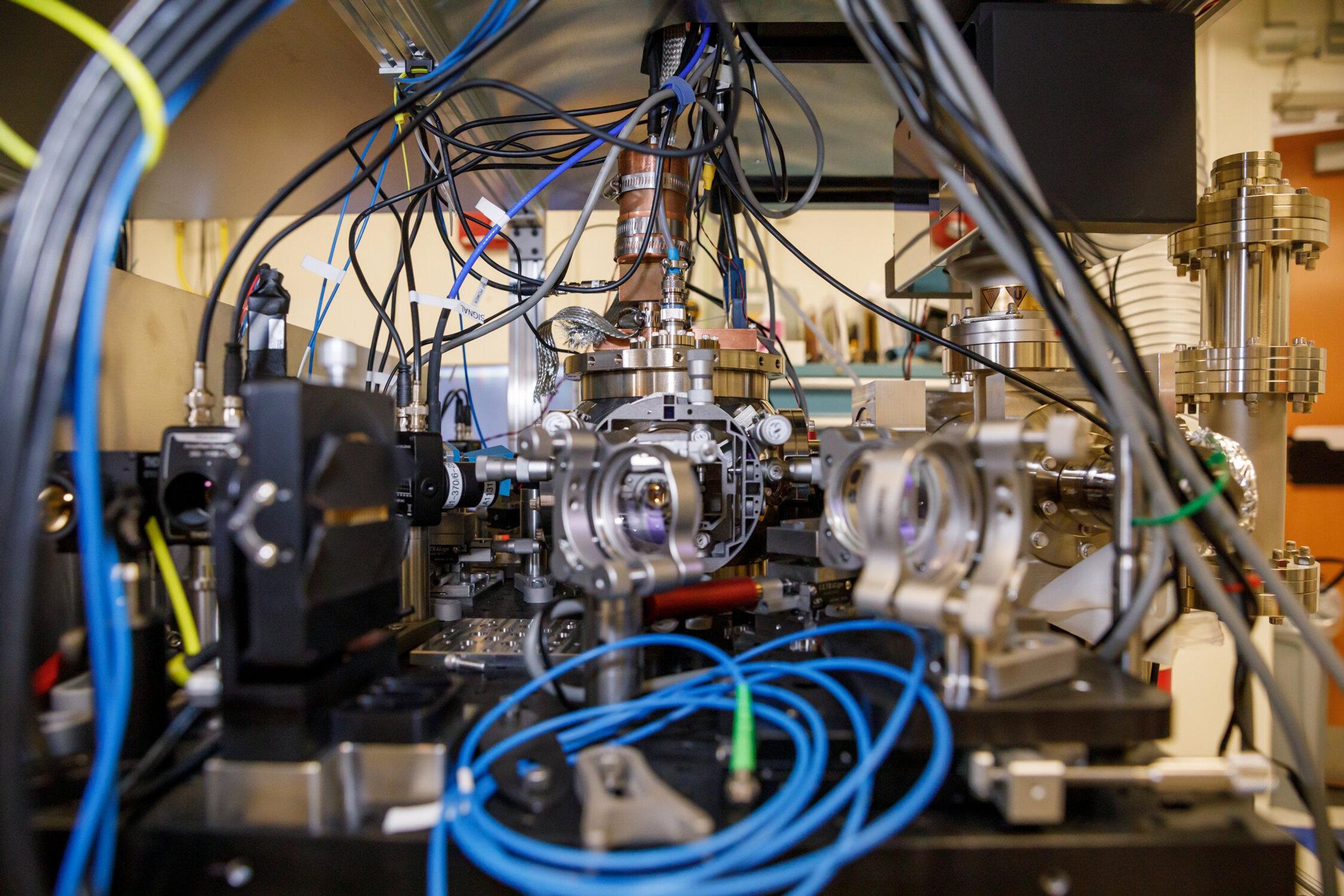 Wires, cryogenics, and optics equipment in a lab bench setting