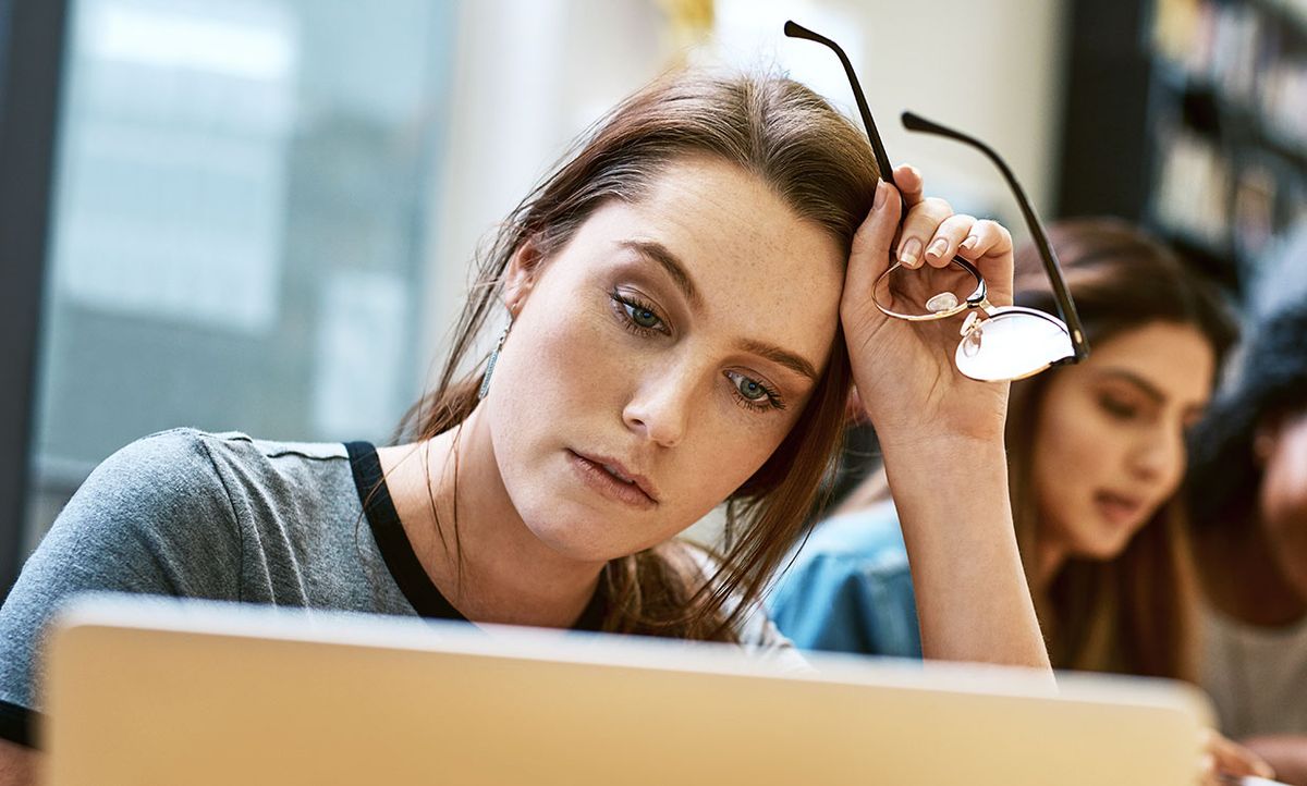 Woman sitting in front of a computer, looking tired.