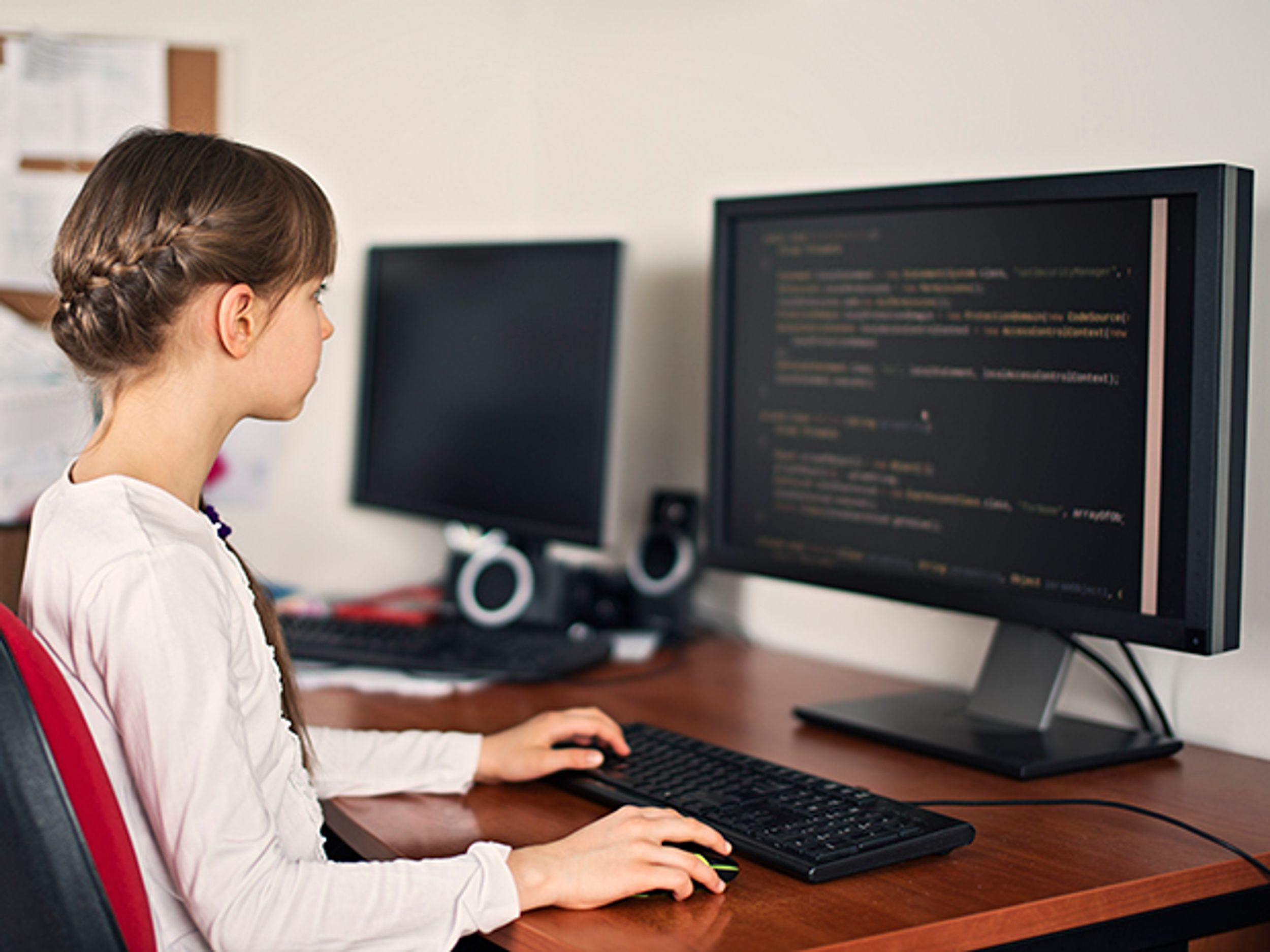 Young girl programming a computer