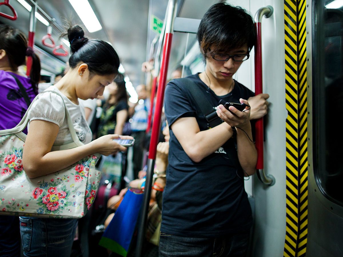 Young mobile users on a subway.